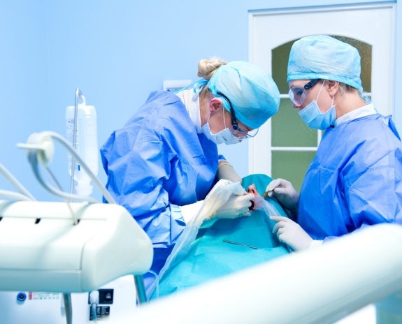 Two dentists treating dental patient
