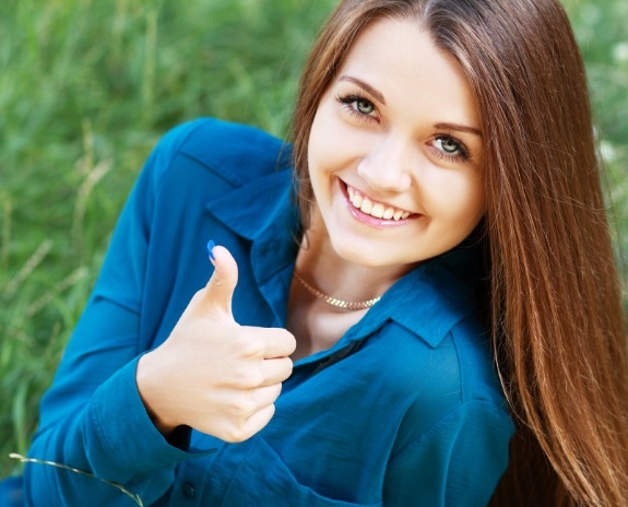 Woman smiling and giving thumbs up