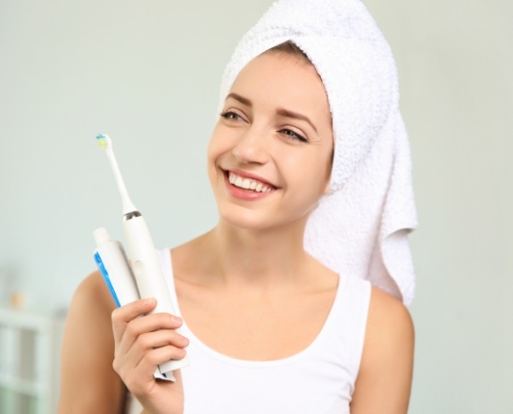 Woman brushing teeth after oral cancer screening